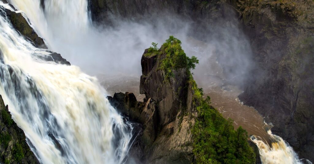 Barron Falls near Cairns featuring rushing water and a large boulder.