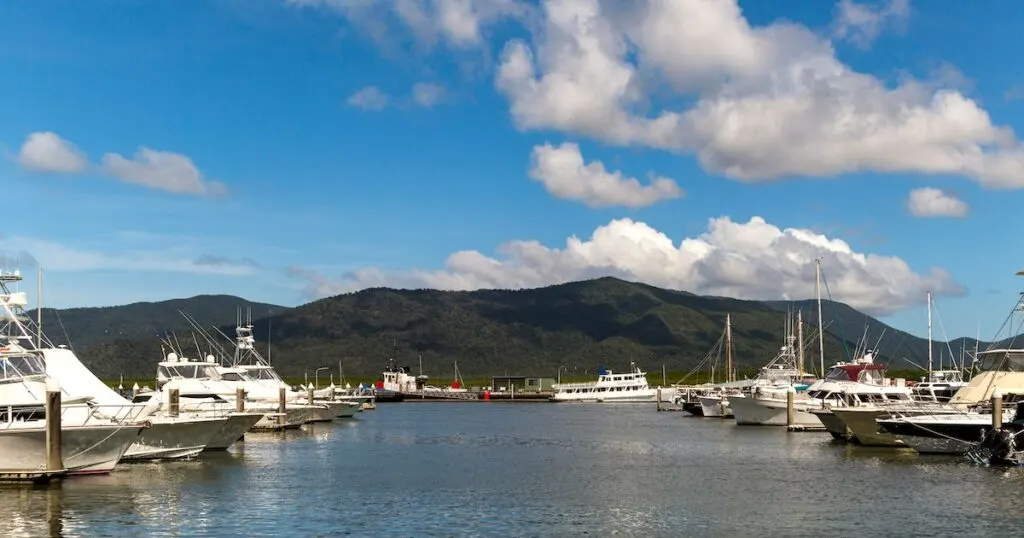 Boats parked at the Cairns Marina, with hills in the background.