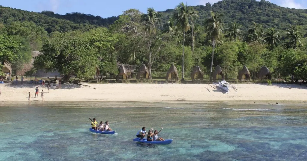 Kayaks carry tourists over shallow reef on a remote island in Linapacan in Palawan , from Coron to El Nido.