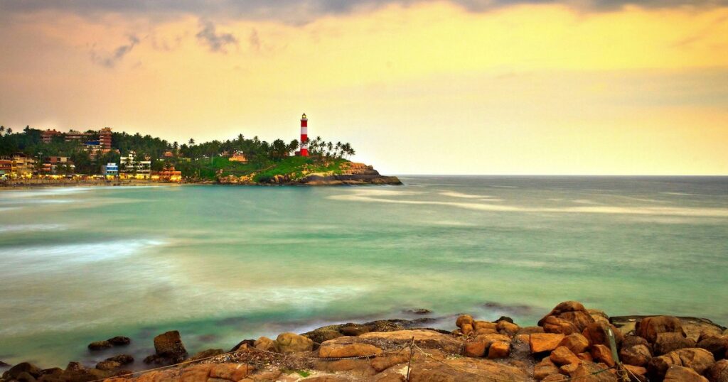 A red lighthouse stands at the end of Kovalam Beach in Kerala.