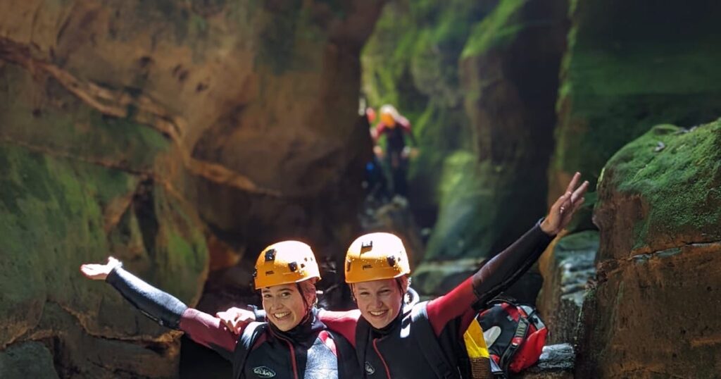 Author and her friend wear helmets and a wetsuit while canyoning at Empress Falls.