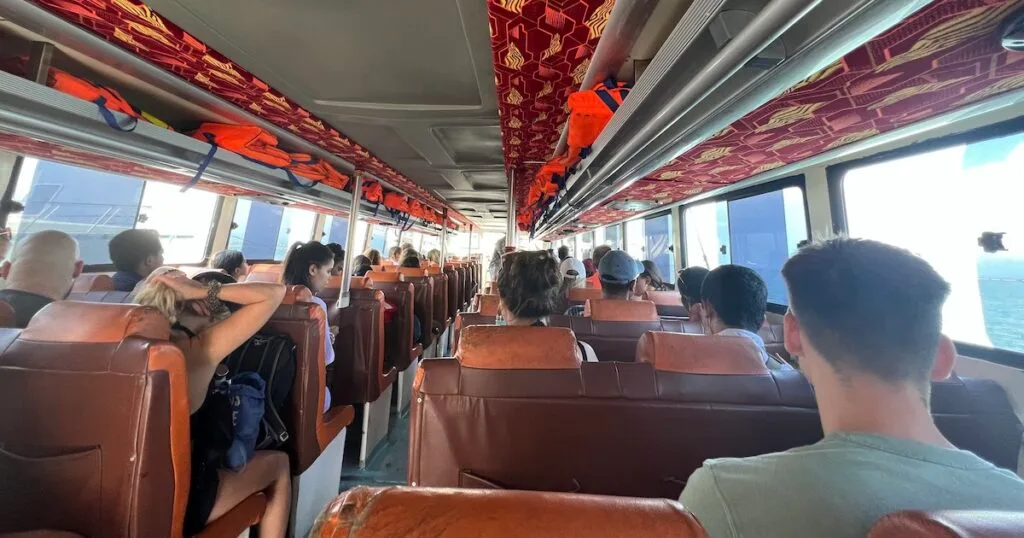 Passengers seated on leather chairs on a fast boat from Sanur to Nusa Penida.