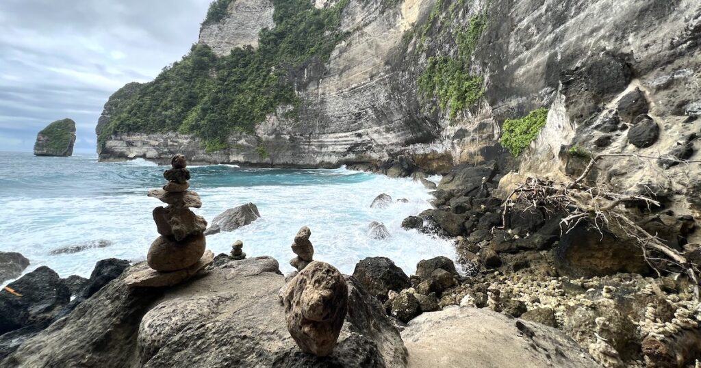 Piles of rocks next to the ocean at Tembeling Beach and Forest in Nusa Penida.